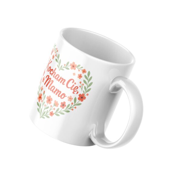 alt="Kubek z napisem Kocham Cię Mamo – widok pod kątem, biały ceramiczny kubek z grafiką serca"