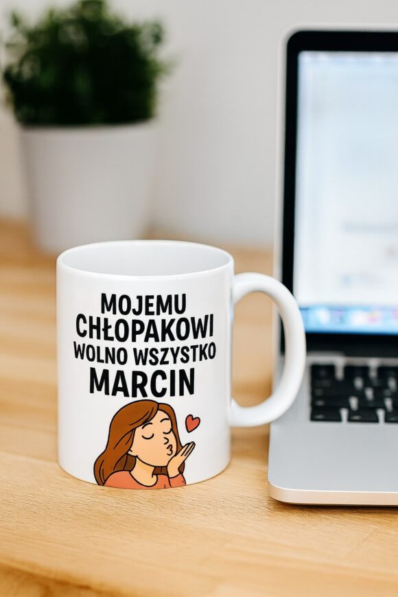 Kubek z nadrukiem Mojemu chłopakowi wolno wszystko Marcin ustawiony na biurku obok laptopa